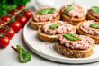 bruschetta with liver pate on a white ceramic plate , selective focus