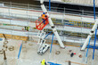 construction workers using a scissor lift aerial work platform to access high columns