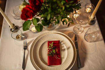 Wall Mural - holidays, dinner party and celebration concept - close up of festive table serving with flowers in vase and candles burning at home on valentine's day