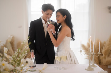 Wall Mural - Bride and groom holding glasses of champagne at the wedding ceremony