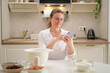 © Андрей Журавлев - Portrait of a woman using a mobile phone in the kitchen. Process of cooking pecan pie in home kitchen for American Thanksgiving Day.