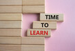Time to learn symbol. Wooden blocks with words Time to learn. Beautiful pink background. Business and Time to learn concept. Copy space.
