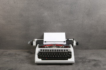 Fototapete - vintage typewriter on the table with blank paper on the grey desk - concept for writing, journalism, blogging