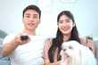 © DG PhotoStock - Lovely Asian young couple relaxing together in living room.