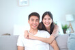 © DG PhotoStock - Lovely Asian young couple relaxing together in living room.