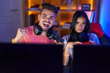 Wall Mural - Man and woman streamer playing video game with winner expression at gaming room