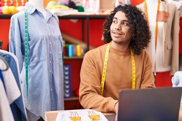 Poster - Young latin man tailor smiling confident using laptop at atelier