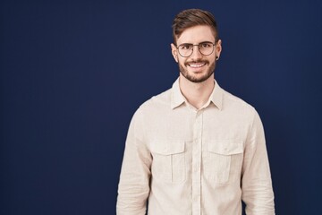 Poster - Hispanic man with beard standing over blue background with a happy and cool smile on face. lucky person.