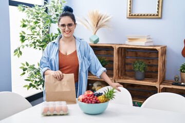 Sticker - Young girl with blue hair holding take away food at the dinning room looking positive and happy standing and smiling with a confident smile showing teeth