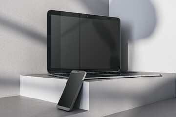 Aufkleber - Close up of empty laptop and smartphone on gray desk. Concrete wall background and pedestal or podium. Device presentation and online education concept. Mock up, 3D Rendering.