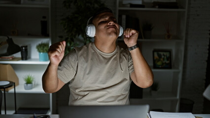 Wall Mural - Young latin man business worker dancing using laptop at the office