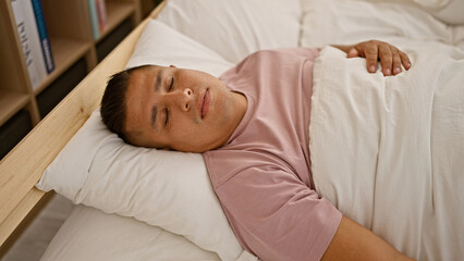 Wall Mural - Exhausted young latin man finds serene comfort at home, relaxing as he falls asleep on the cozy bed of his indoor bedroom, resting amidst the background of morning tranquility.