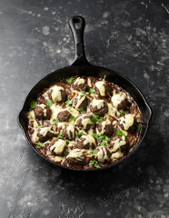 Wall Mural - French onion beef meatballs in iron cast pan.