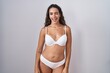 © Krakenimages.com - Young hispanic woman wearing white lingerie winking looking at the camera with sexy expression, cheerful and happy face.