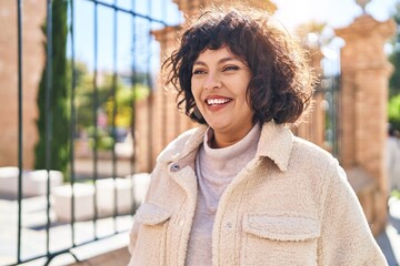 Wall Mural - Young beautiful hispanic woman smiling confident looking to the side at street