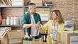 © Krakenimages.com - Man and woman volunteers putting products on package to donate at charity center