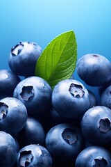 Poster - A close-up view of a bunch of plump and juicy blueberries with a vibrant green leaf. Perfect for food and nutrition-related projects