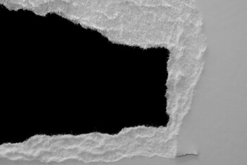 Wall Mural - edge of a torn white sheet of paper on a black background, black hole