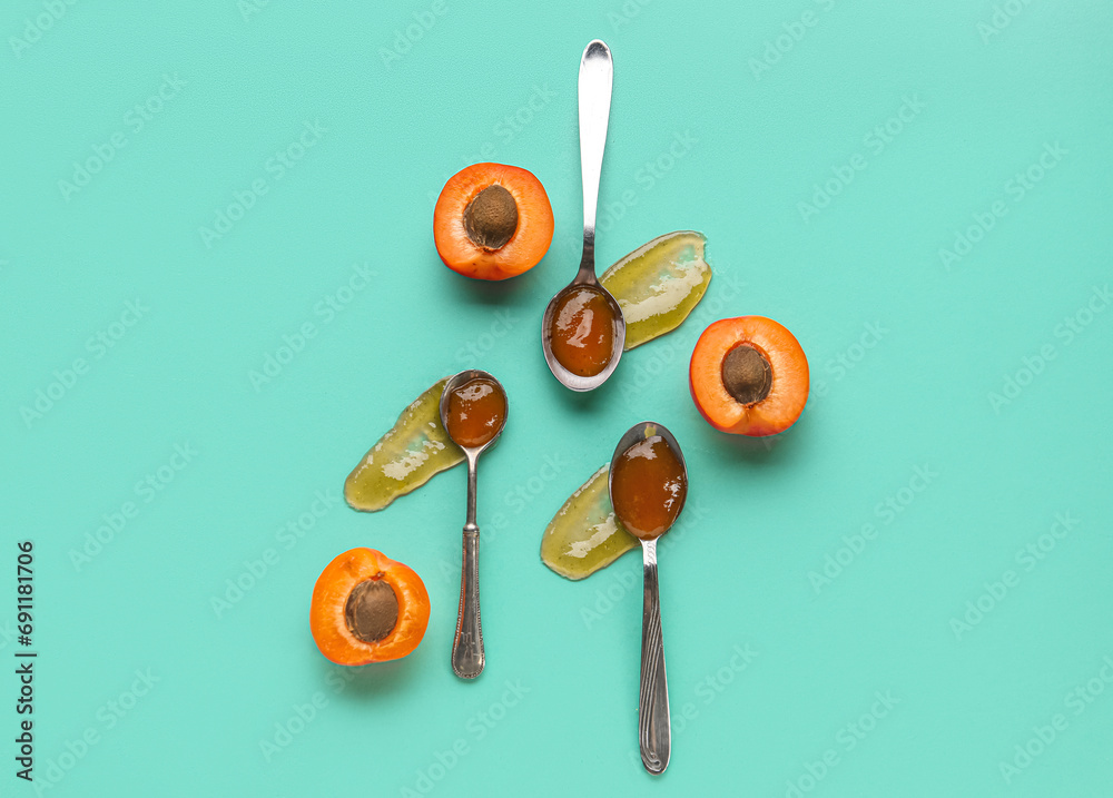 Metal spoons with sweet apricot jam on green background