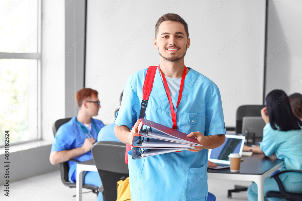 Male medical student with folders at university