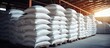 Chemical fertilizer urea stock piles of big jumbo bags loaded on trailers parked in warehouses awaiting delivery. Copy space image. Place for adding text