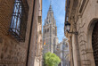 The Primatial Cathedral of Saint Mary of Toledo appears through the streets in historic Toledo, Spain