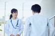 病院内にてリハビリを行う患者と見守る女性医師