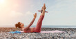 Woman sea pilates. Sporty happy middle aged woman practicing fitness on beach near sea, smiling active female training with ring on yoga mat outside, enjoying healthy lifestyle, harmony and meditation