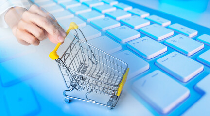 Poster - Miniature shopping cart. Supermarket trolley on keyboard. E-commerce concept. Empty shopping cart. Digital retail. E-commerce technologies. Selling goods via internet. E-commerce business