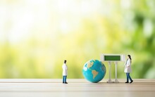 Happy Earth And World Health Day Poster With A Small Globe, Miniature Doctor Figures On Wooden Table Surface. Green Blurred Background, Copy Space, Day Light, Close Up, Bokeh, De Focus. AI Generative