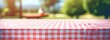 © olegganko - a tablecloth covered with a gingham pattern with blurred background