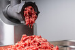 raw beef minced meat comes out of mincing machine mincer front view close up banners advertising