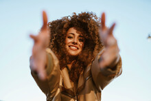 Happy Woman With Curly Hair Dancing Under Sky