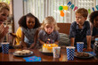 © Westend61 - Boy blowing candles on his birthday cake with friends watching