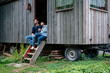 © Westend61 - Smiling couple sitting in doorway of log cabin