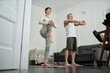 © Westend61 - Couple doing stretching exercises in morning at home
