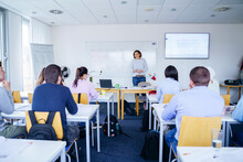 Woman Teaching To Multi-ethnic Students In Classroom