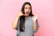 Young Colombian woman isolated on pink background making phone gesture and doubting