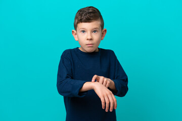 Wall Mural - Little kid boy isolated on blue background making the gesture of being late