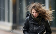 Frozen girl with tousled long hair on a bad windy winter day