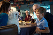 Smiling woman with dog in hands celebrating Thanksgiving day in restaurant