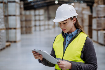 Wall Mural - Female warehouse worker reading product order, order picking. Warehouse manager checking delivery, stock in warehouse, inspecting products for shipment.