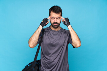 Wall Mural - Young sport man with beard over isolated blue background with headache
