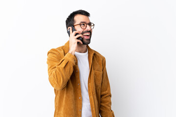 Wall Mural - Caucasian handsome man with beard wearing a corduroy jacket over isolated white background keeping a conversation with the mobile phone