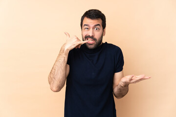 Wall Mural - Caucasian handsome man over isolated background making phone gesture and doubting