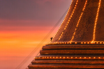 Wall Mural - Buddhists climb up to light decoration the golden pagoda Phra Pathom Chedi on sunset sky in annual festive at Nakhon Pathom