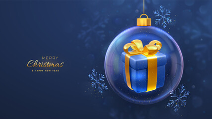 Wall Mural - Merry christmas greeting card. Gift box with golden bow in a transparent glass bauble. Christmas blue background with shining ice showflakes. Holiday Xmas, New Year banner, flyer. Vector Illustration.