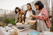 Southeast asian mother with her daughters having fun preparing Thai food recipe together at house patio
