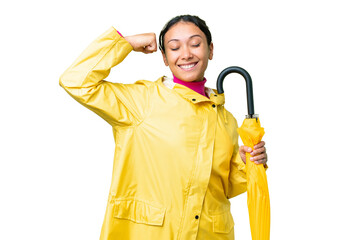 Sticker - Young Uruguayan woman with rainproof coat and umbrella over isolated chroma key background doing strong gesture