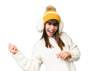 Canvas Print - Little caucasian girl wearing winter muffs over isolated background making guitar gesture